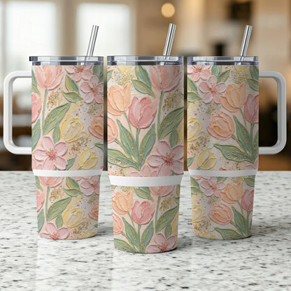 Three insulated tumblers with a floral pattern of pink and yellow tulips.