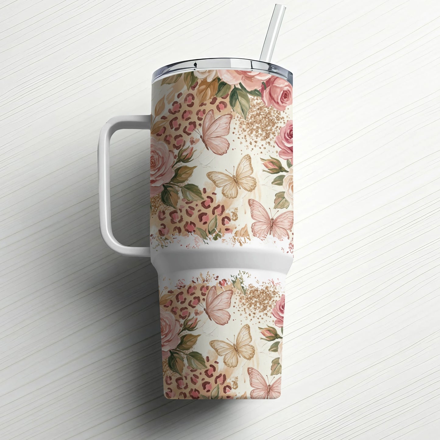 Floral and butterfly pattern travel tumbler with handle and straw.