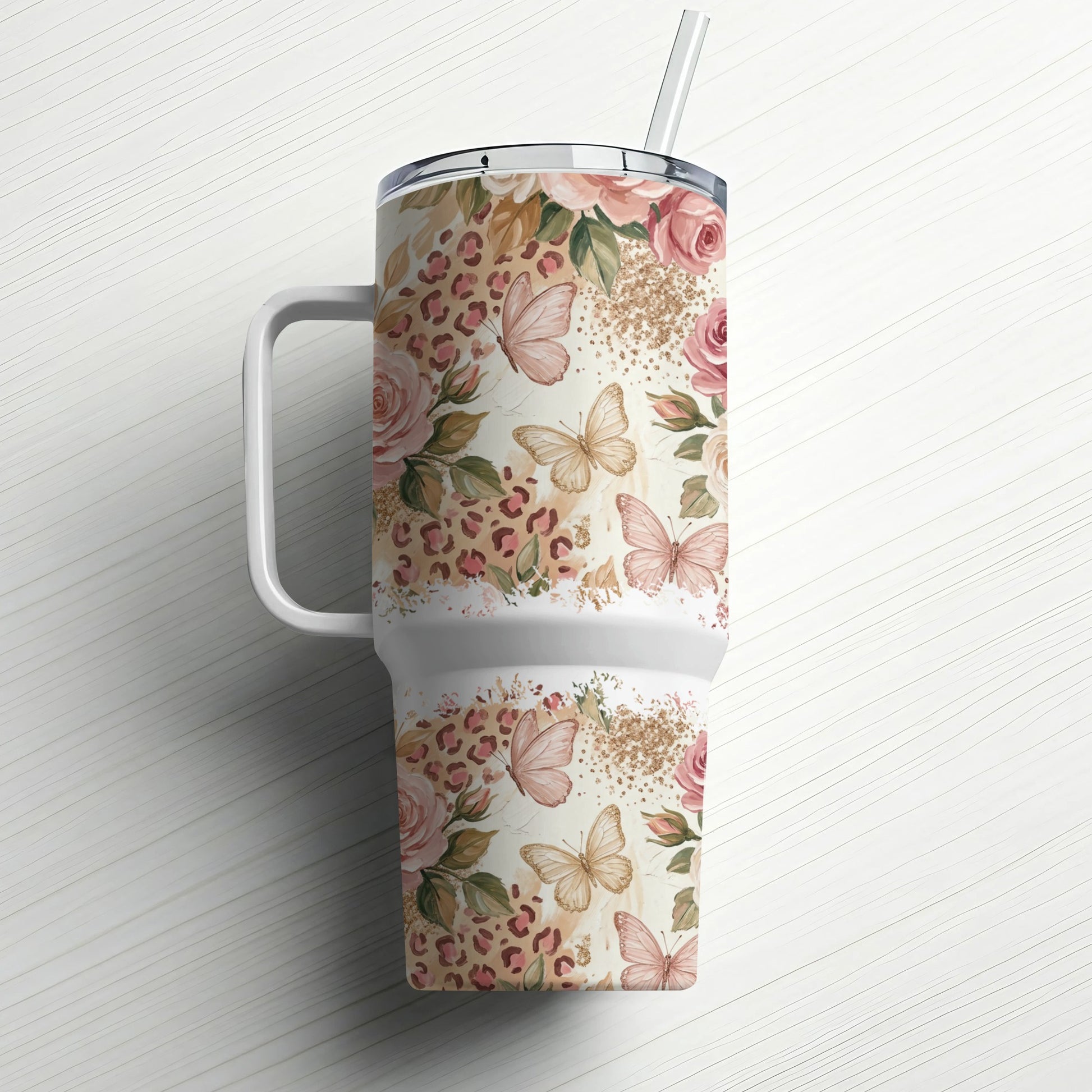Floral and butterfly pattern travel tumbler with handle and straw.