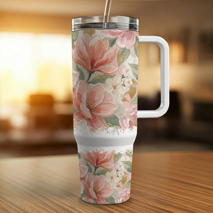 White tumbler with a pink floral watercolor design and a handle.