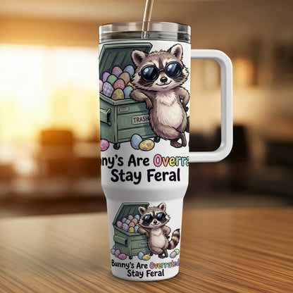 Raccoon wearing sunglasses leans against a trash can; text reads "Bunny's Are Overrated Stay Feral."
