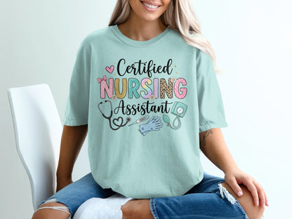 Certified Nursing Assistant text with medical icons on light blue t-shirt.