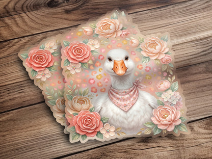 White goose wearing pink bandana, surrounded by pastel flowers on a wooden background.