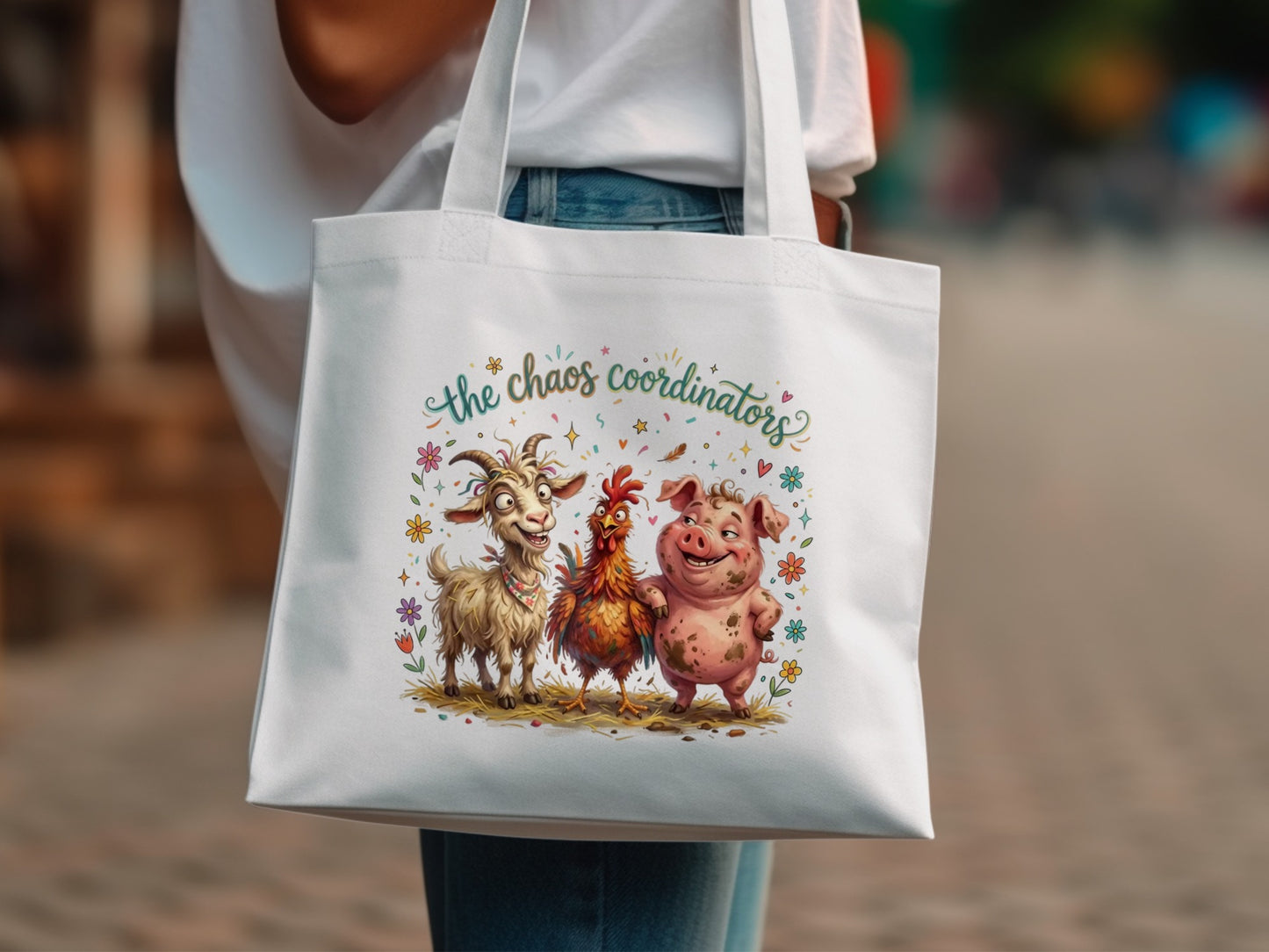 White tote bag with cartoon goat, chicken, and pig under "The Chaos Coordinators" text.