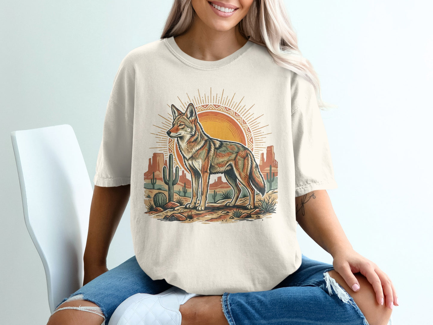 T-shirt with desert landscape featuring a coyote, cactus, and sun.