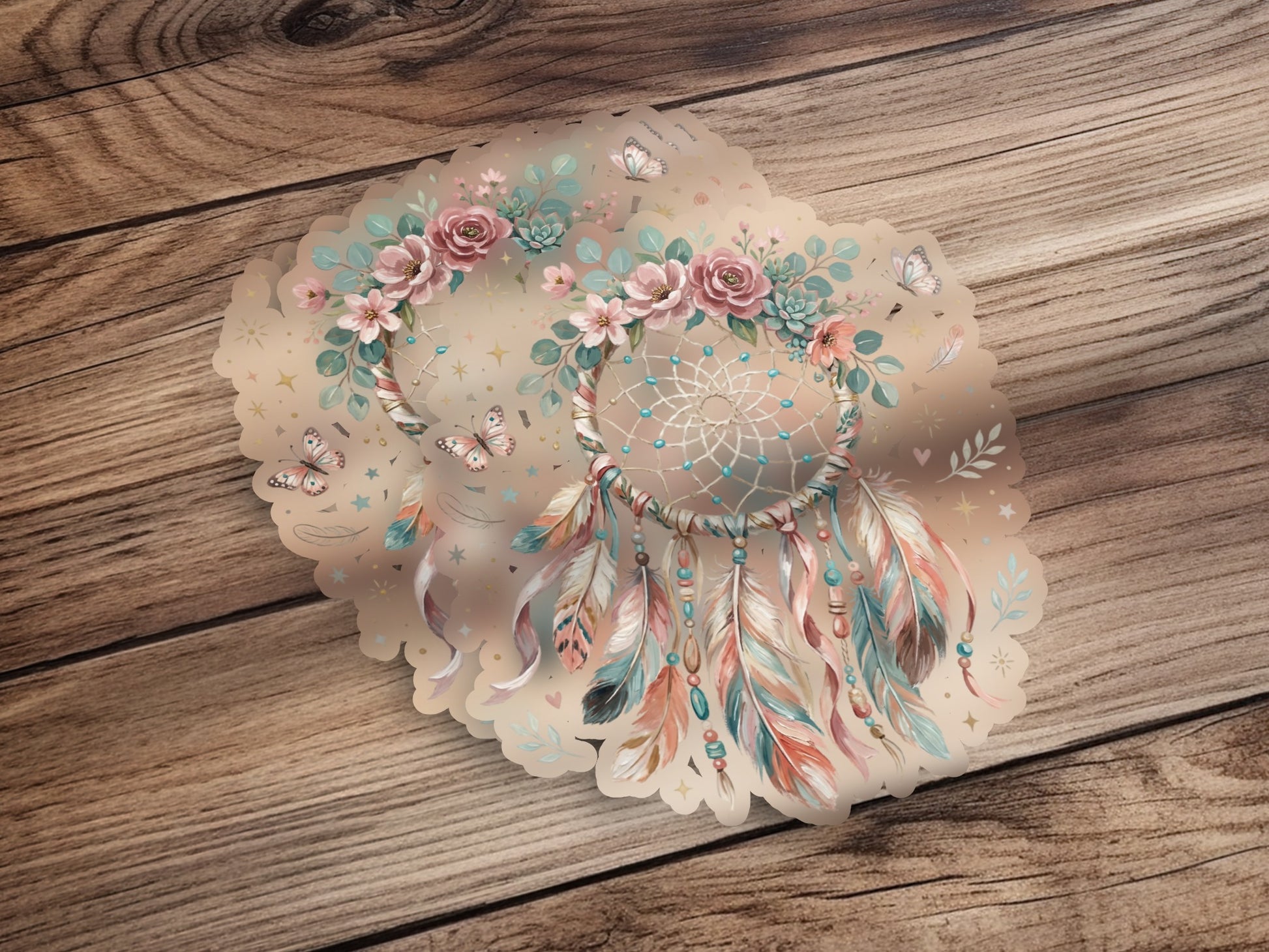 Dreamcatcher with floral accents, feathers, and butterflies on a wooden background.