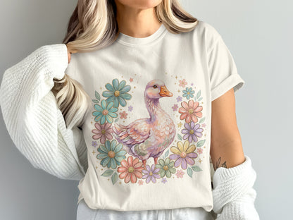 Cream t-shirt with a pastel duck surrounded by colorful flowers.