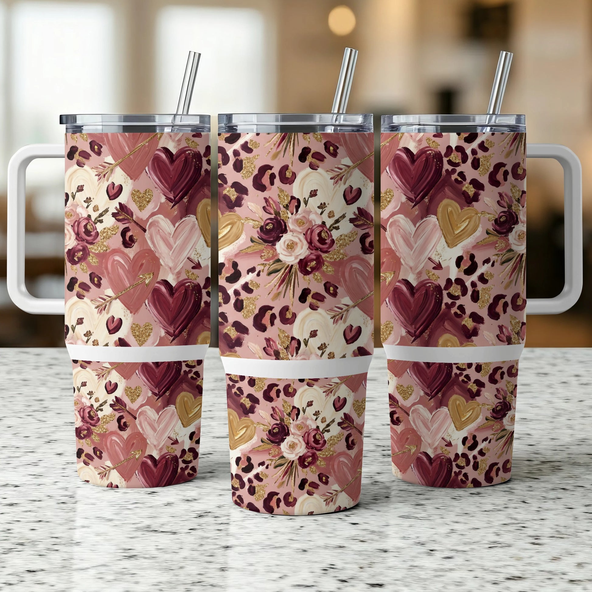 Three tumblers with heart and floral leopard print design, on a speckled counter.