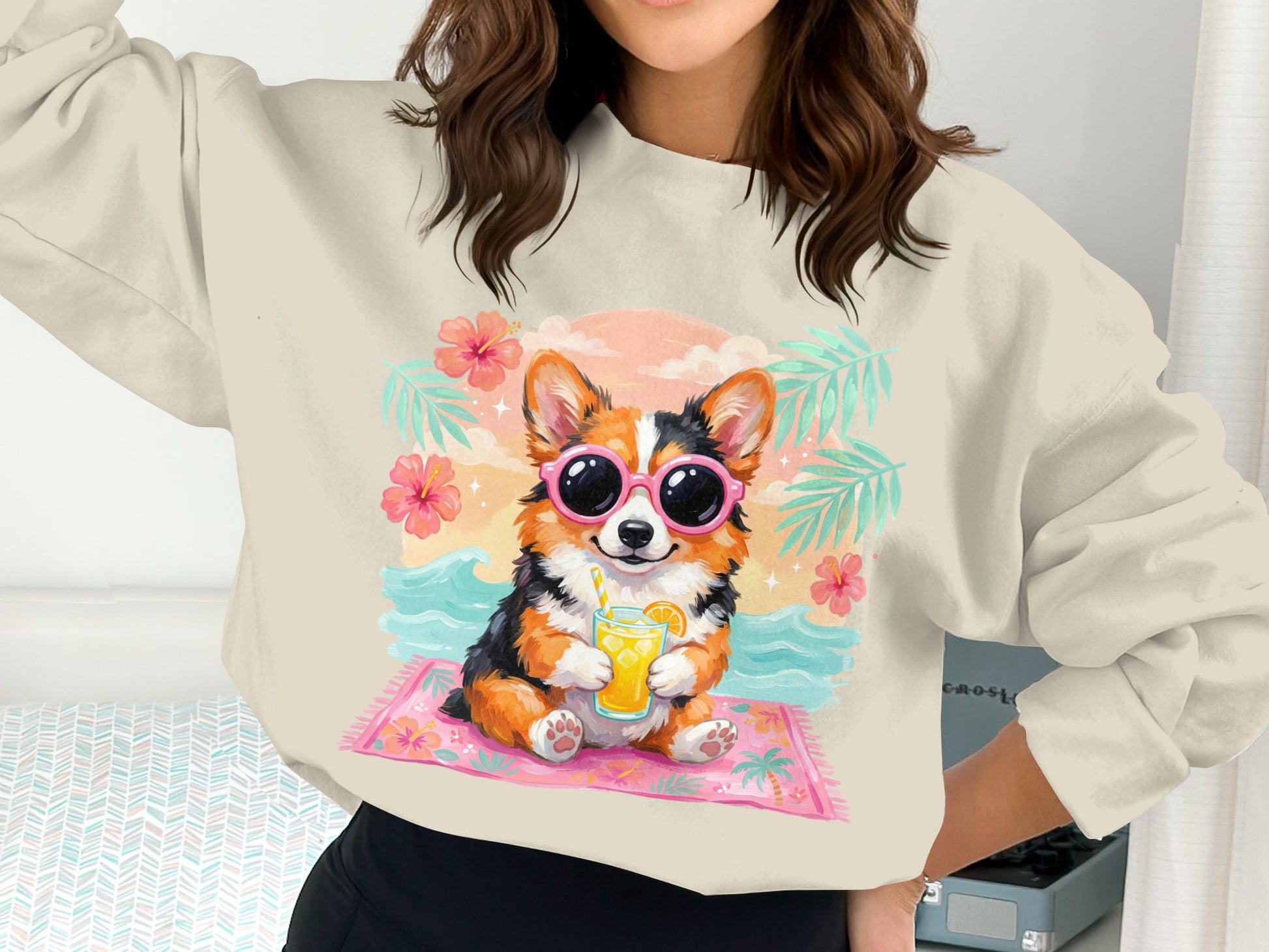 Corgi wearing sunglasses drinks juice on a beach mat.