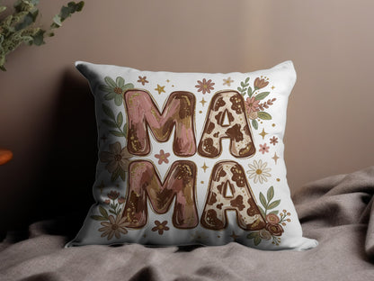 Decorative pillow with "MAMA" in floral and cow print letters.