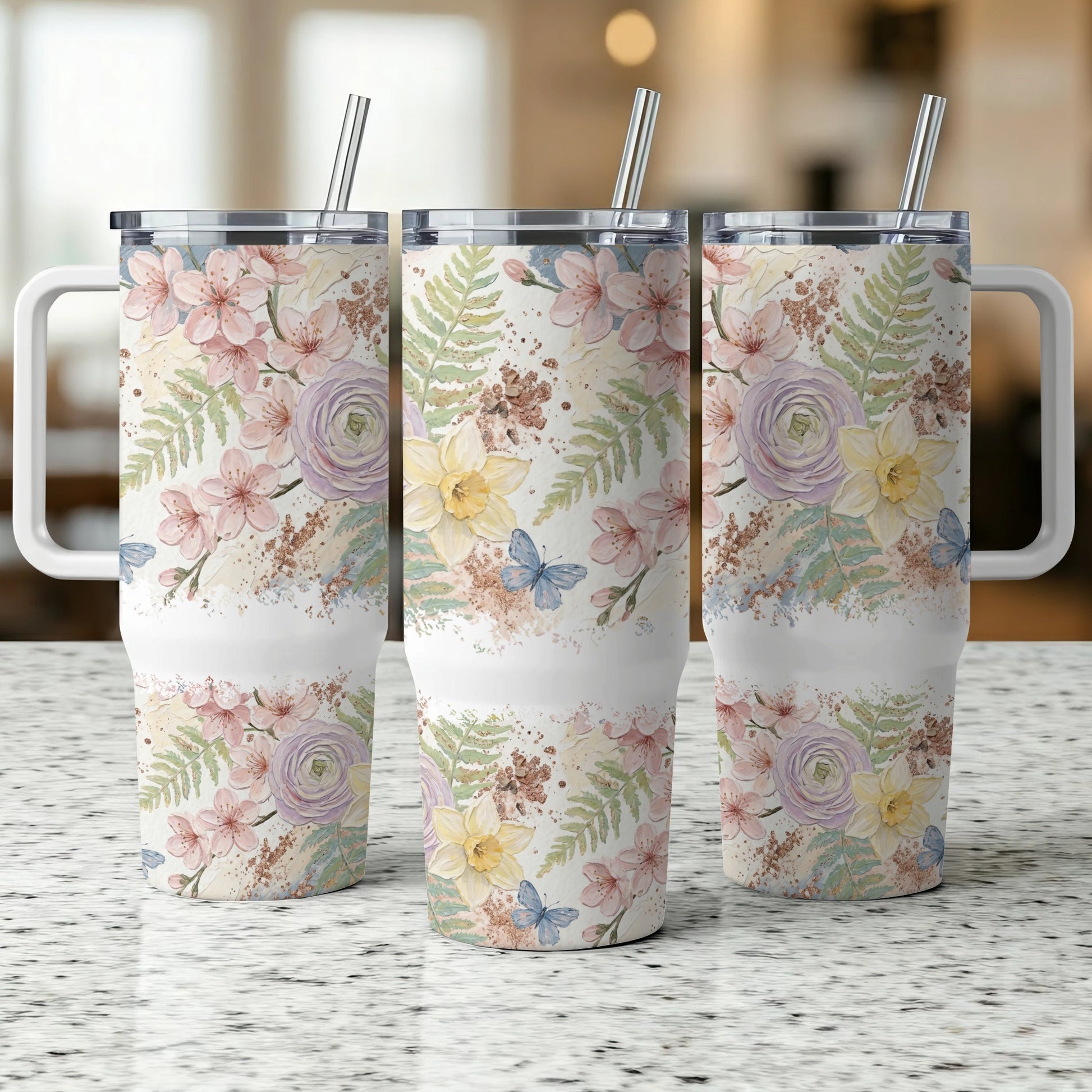 Three tumblers with floral and butterfly pattern, blurred background.