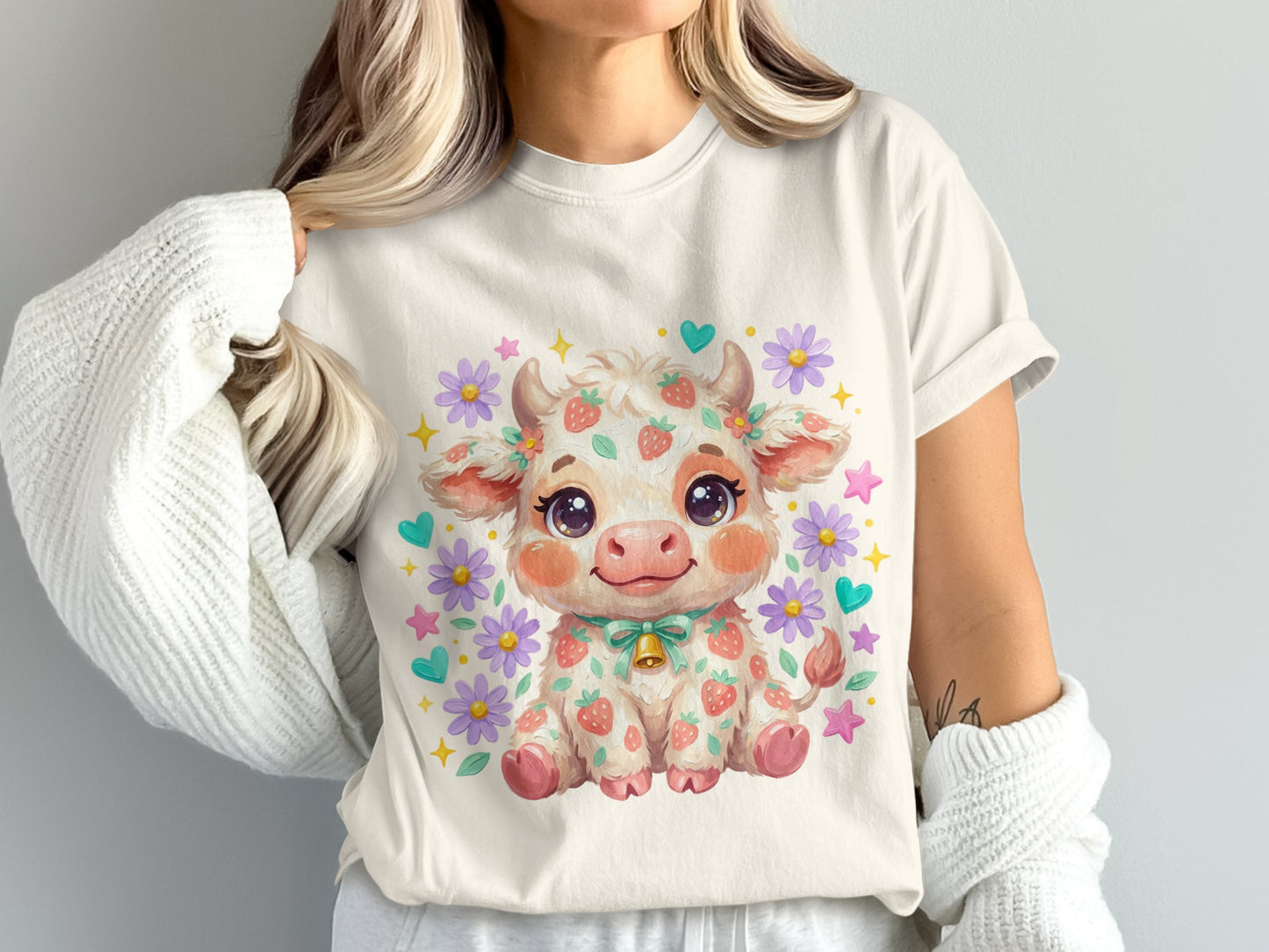 Kawaii strawberry cow with flowers and a bell on a light t-shirt.