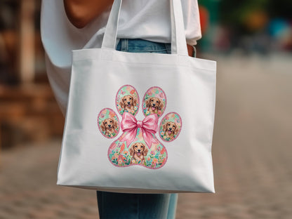 White tote bag with a floral paw print featuring golden retriever puppies and a pink bow.