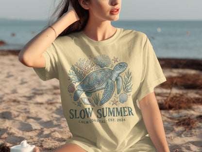 T-shirt featuring a sea turtle, coral, and shells with "Slow Summer" text.