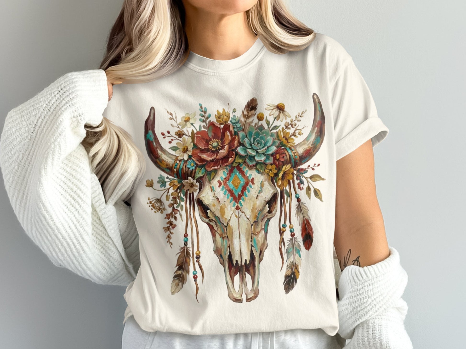 T-shirt with watercolor skull adorned with flowers, feathers, and geometric pattern.