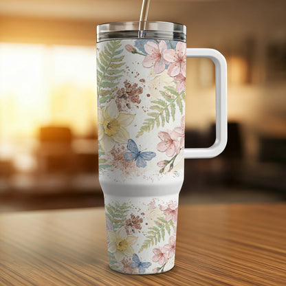White tumbler with pink cherry blossoms, yellow daffodils, and blue butterflies.