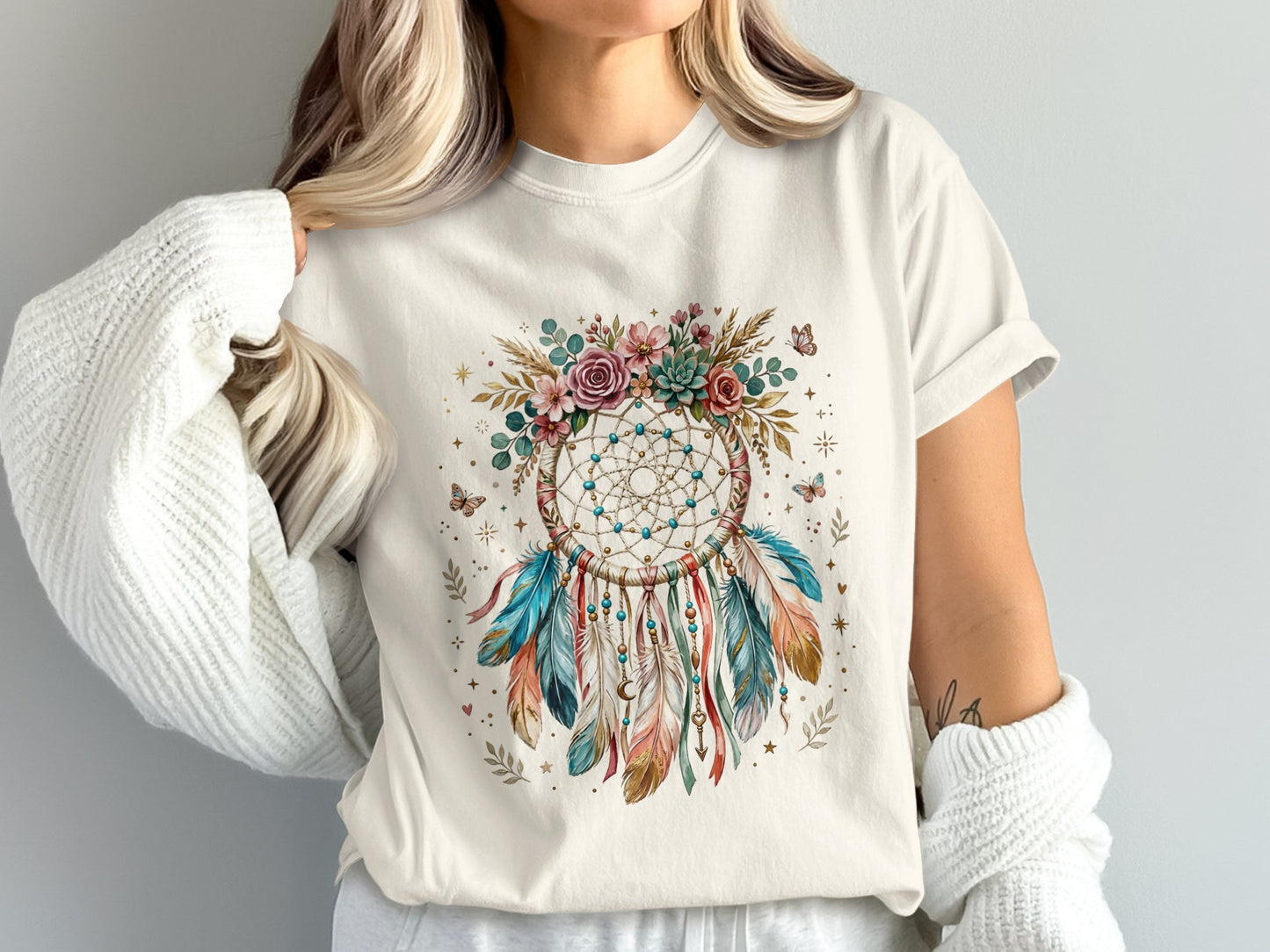 Cream t-shirt with a dreamcatcher design featuring feathers and butterflies.