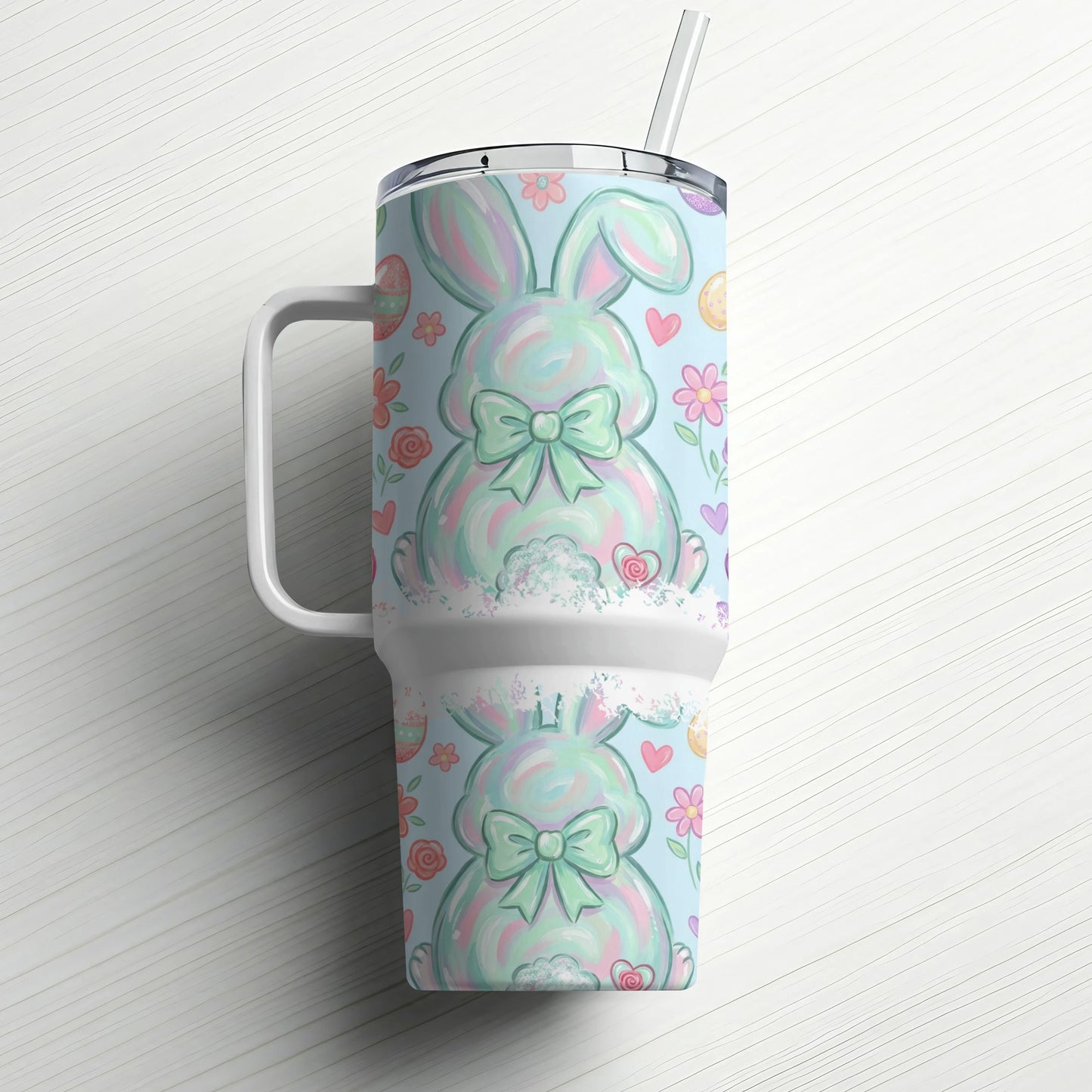 Blue tumbler with pastel Easter bunny pattern and straw.