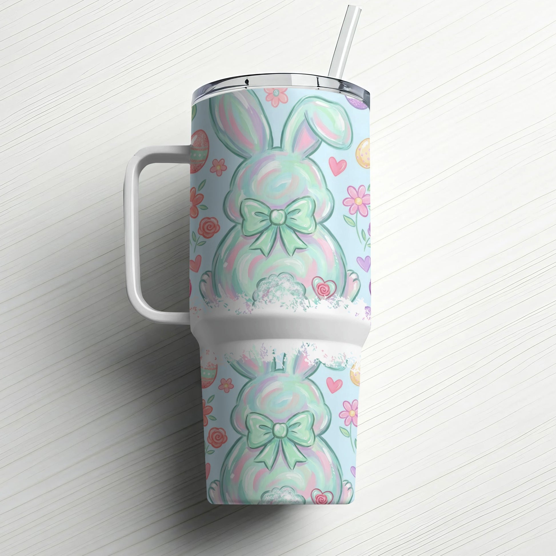 Blue tumbler with pastel Easter bunny pattern and straw.