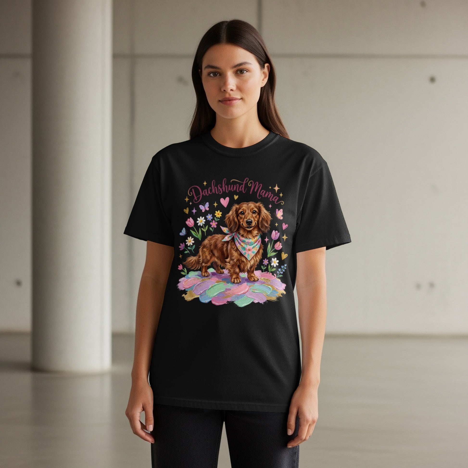 Black t-shirt with a dachshund wearing a bandana surrounded by flowers and feathers.