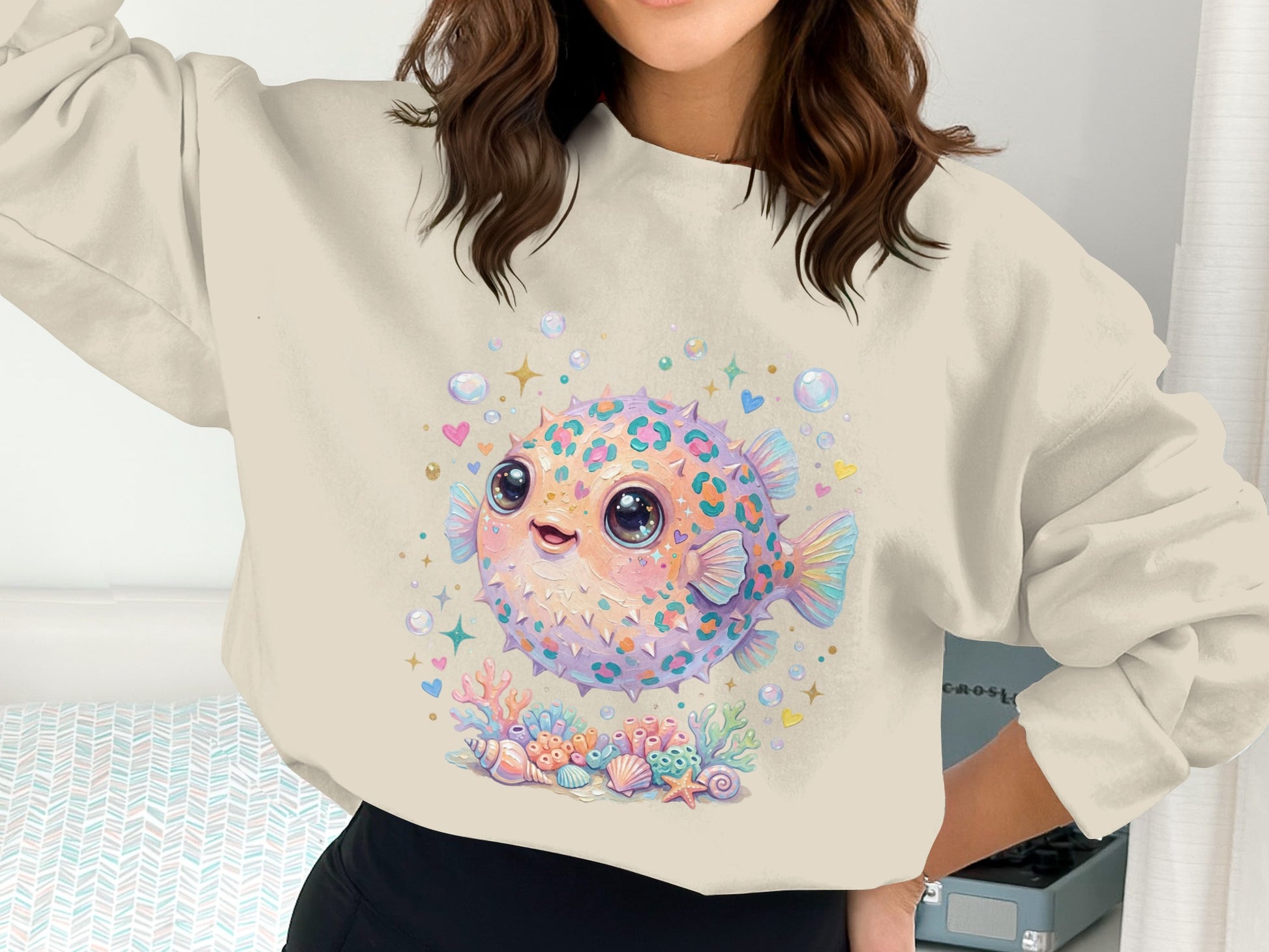 Pufferfish and seashells graphic on a cream sweatshirt.