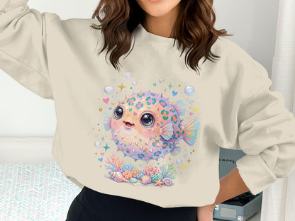 Pufferfish and seashells graphic on a cream sweatshirt.