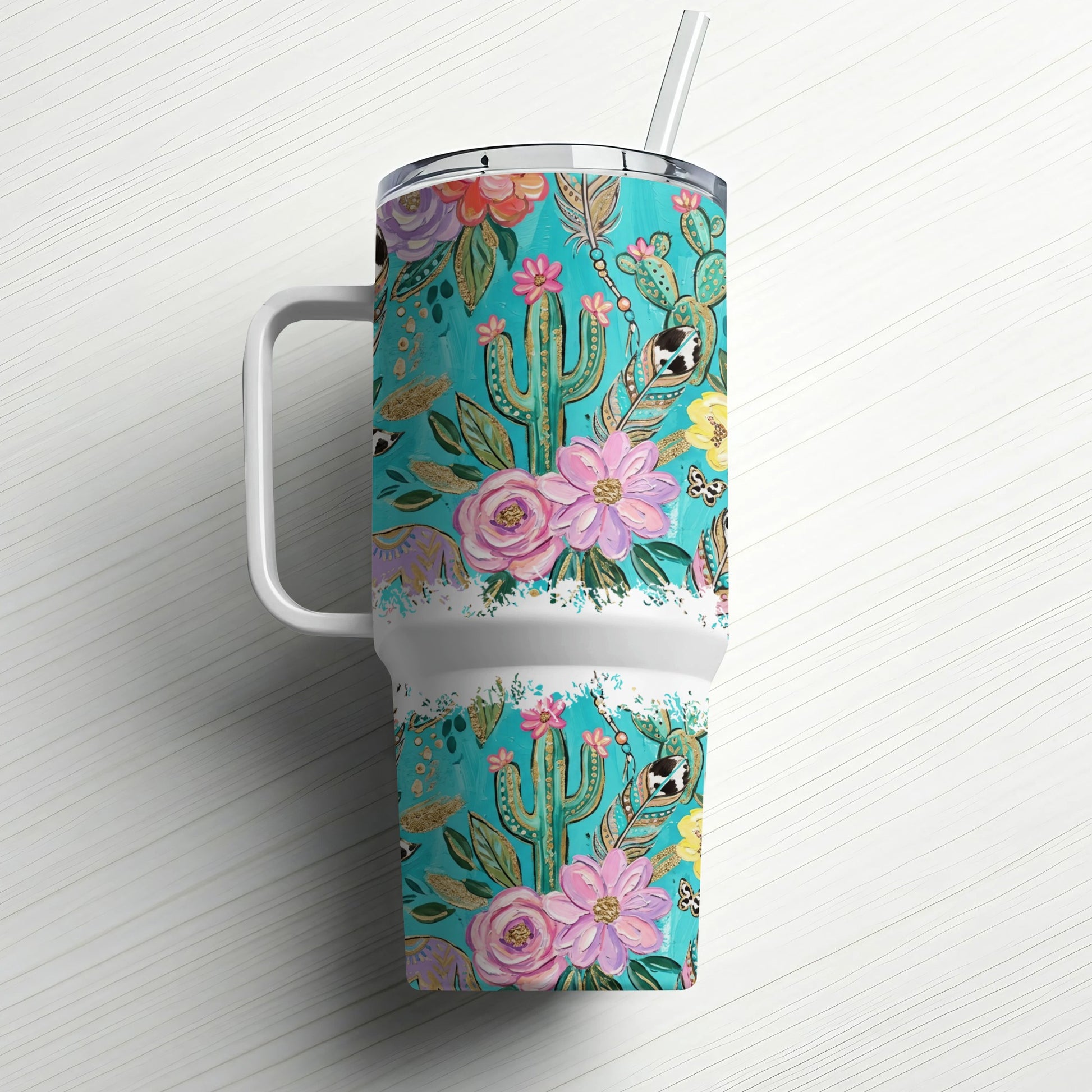 Turquoise tumbler with a floral and cactus pattern and a straw.