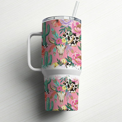 Pink tumbler with cow skull, cactus, and floral pattern, white handle and straw.