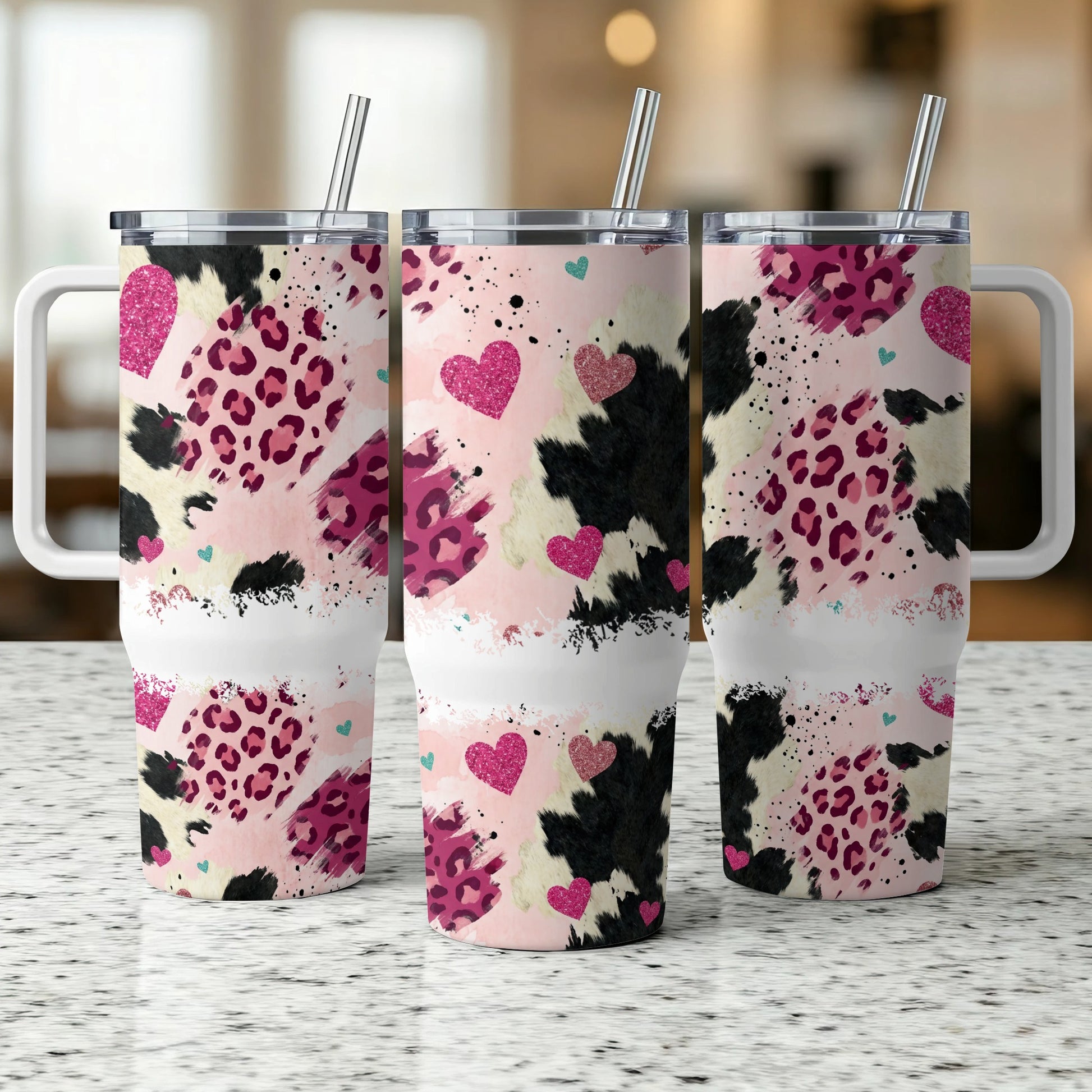 Three patterned tumblers with pink hearts and animal print designs.