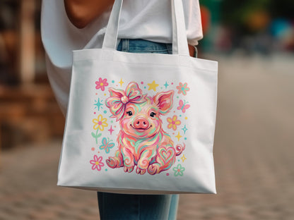 White tote bag with a colorful cartoon pig wearing a bow and surrounded by flowers.