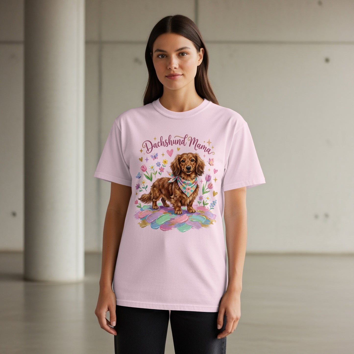 Dachshund Mama graphic on a light pink t-shirt with a dog and feathers.