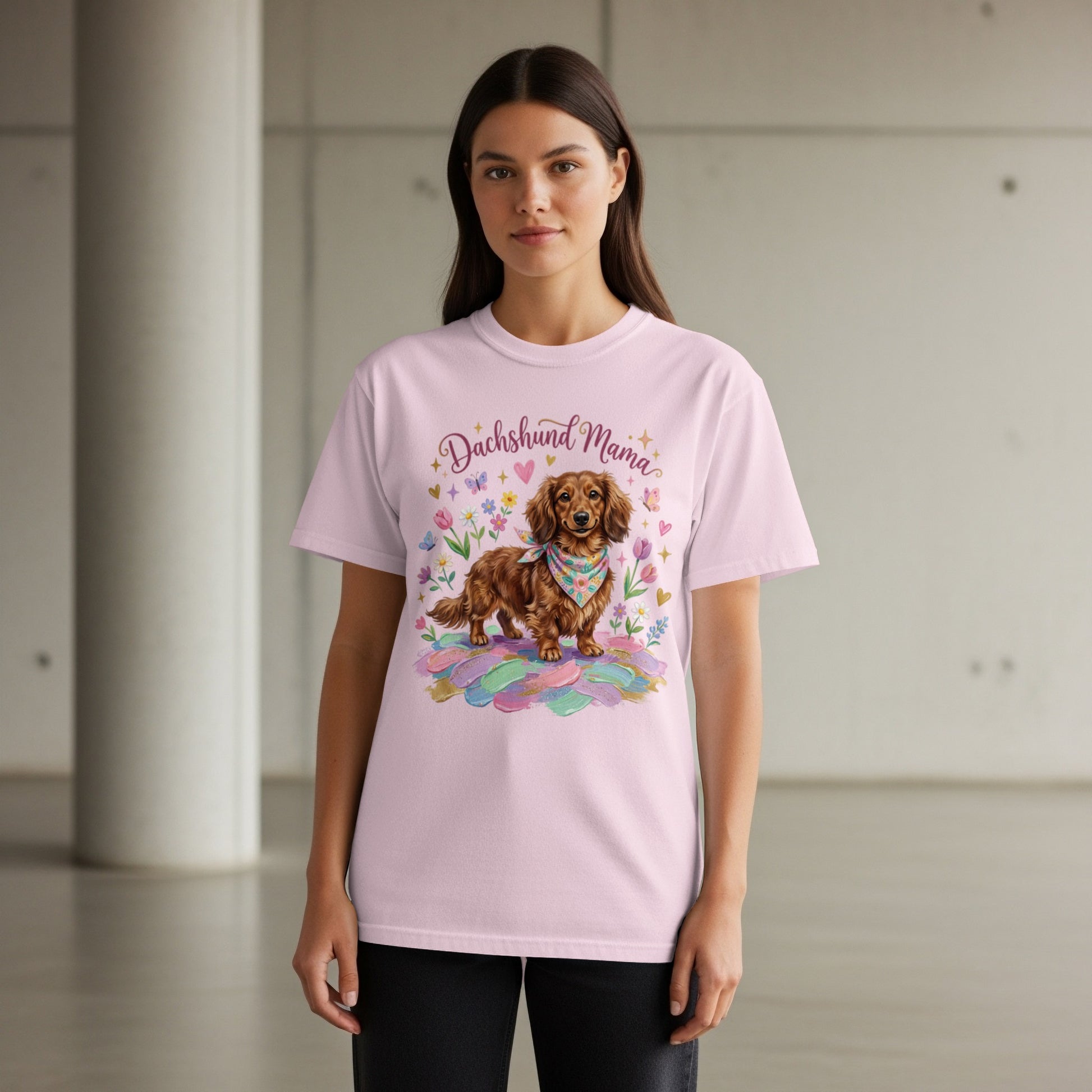 Dachshund Mama graphic on a light pink t-shirt with a dog and feathers.