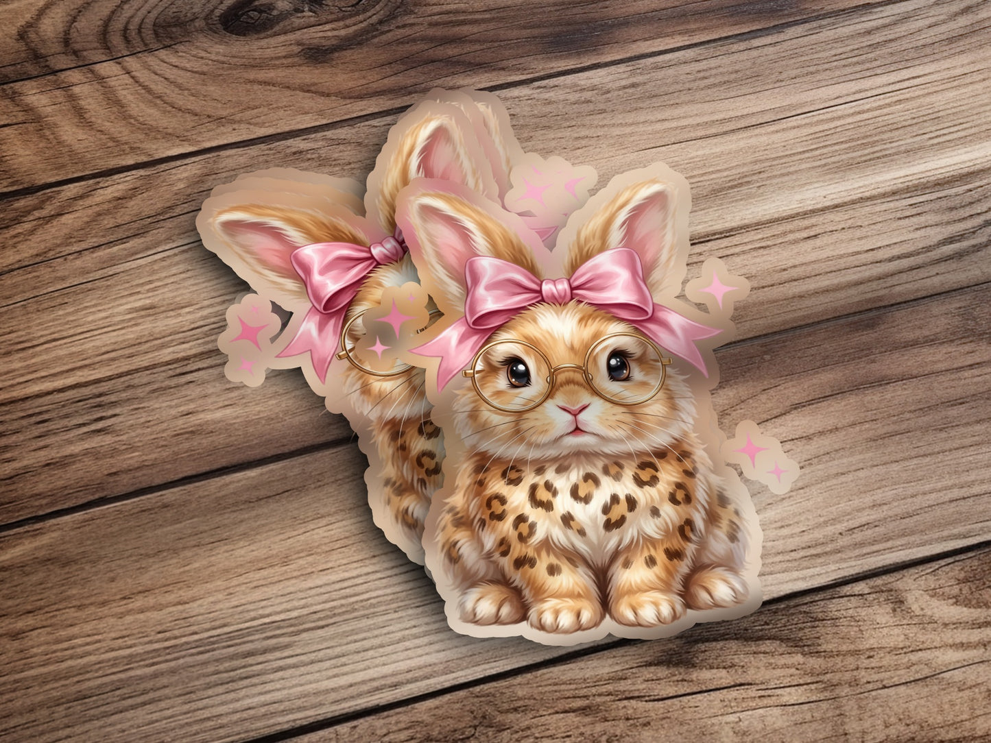 Two cute bunnies with glasses and pink bows on wooden background.