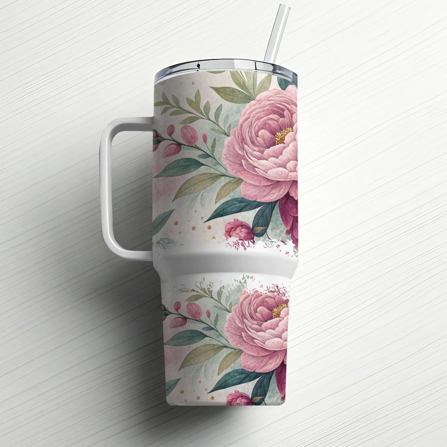 White tumbler with pink floral pattern and handle, with a straw.