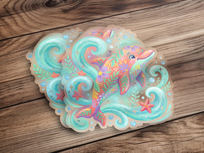 Whimsical dolphin sticker with colorful floral patterns on a wooden background.