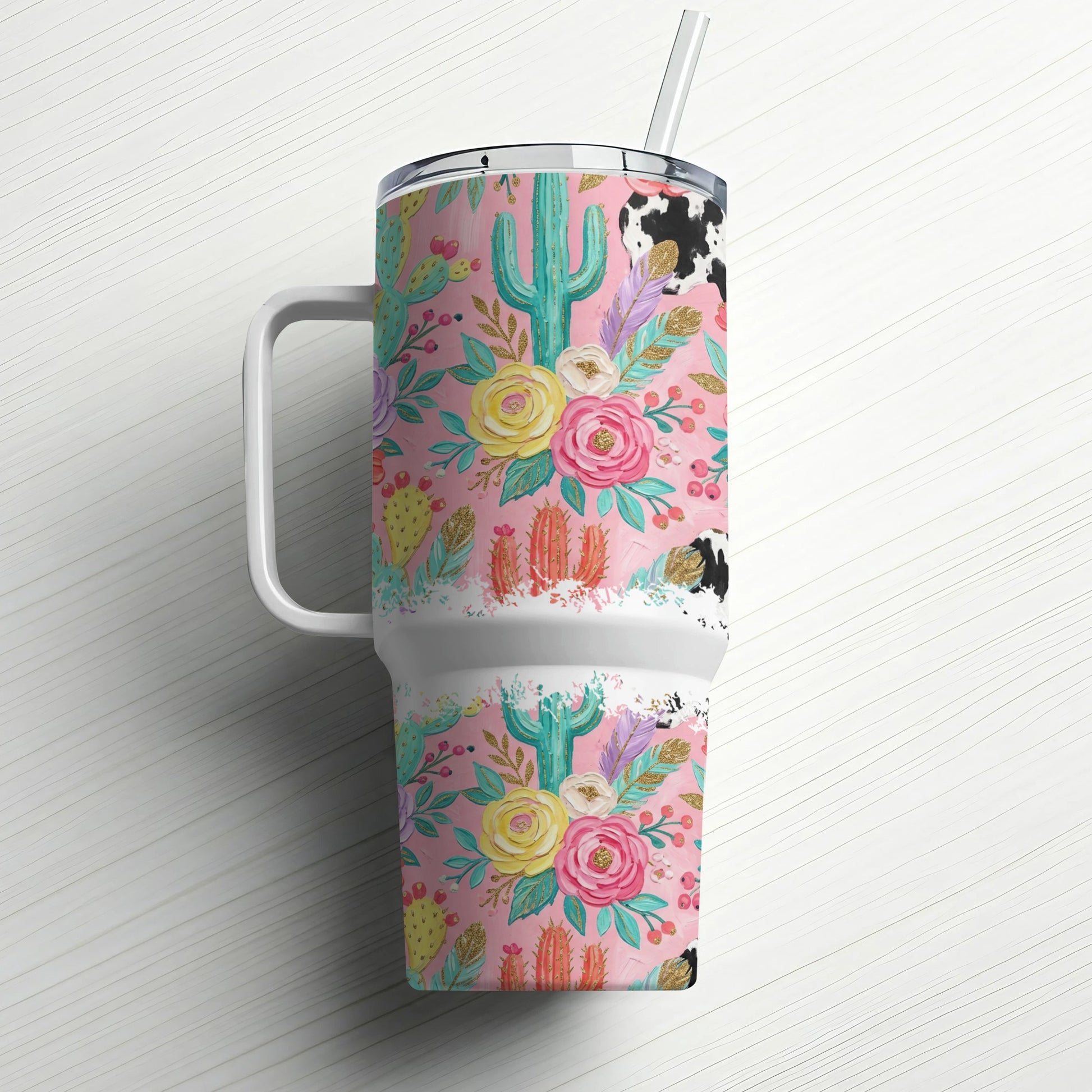 Pink floral and cactus tumbler with cow print lid and straw.