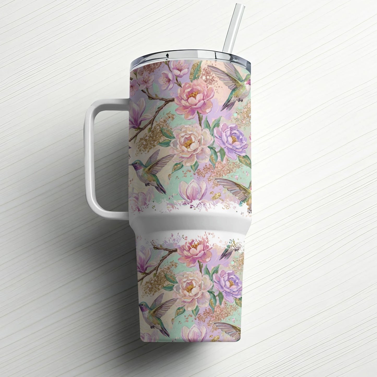 Floral and hummingbird pattern on a white insulated tumbler with straw.