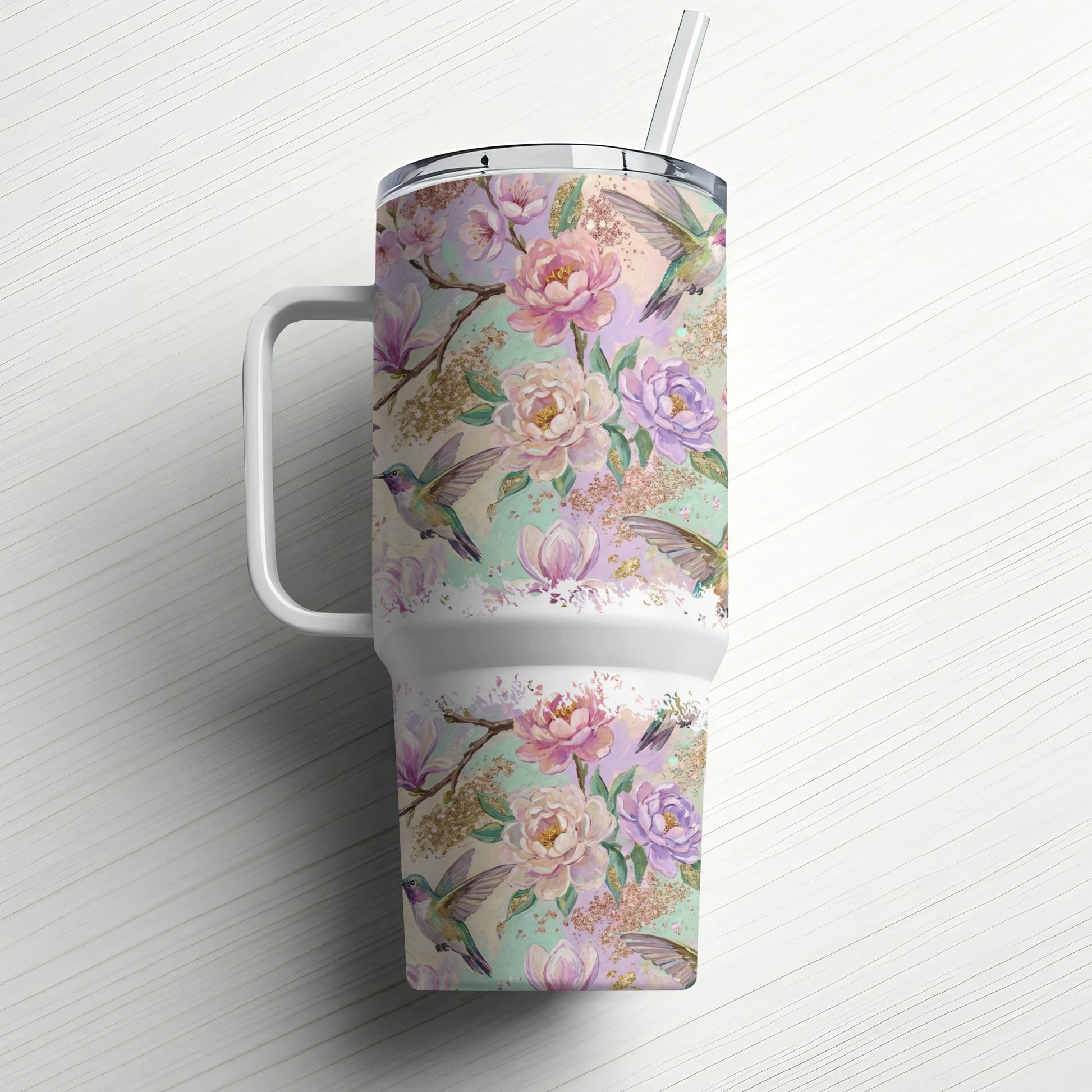 Floral and hummingbird pattern on a white insulated tumbler with straw.
