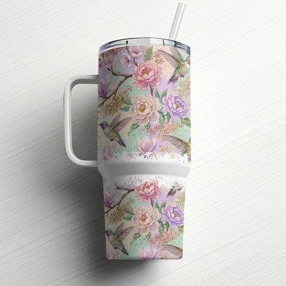 Floral and hummingbird pattern on a white insulated tumbler with straw.
