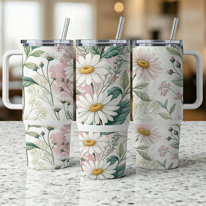 Three tumblers with a daisy floral pattern stand on a speckled surface.
