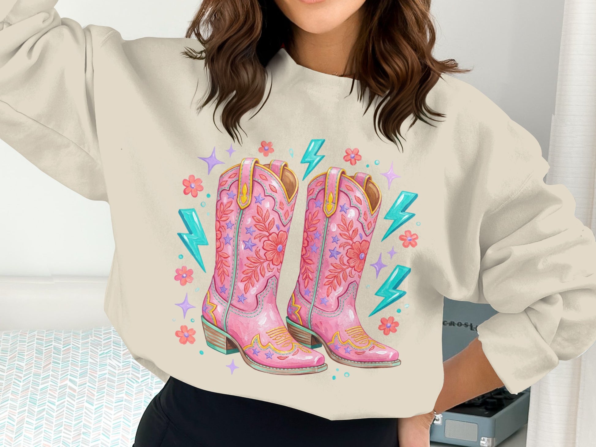 Pink cowboy boots with floral and lightning bolt designs.