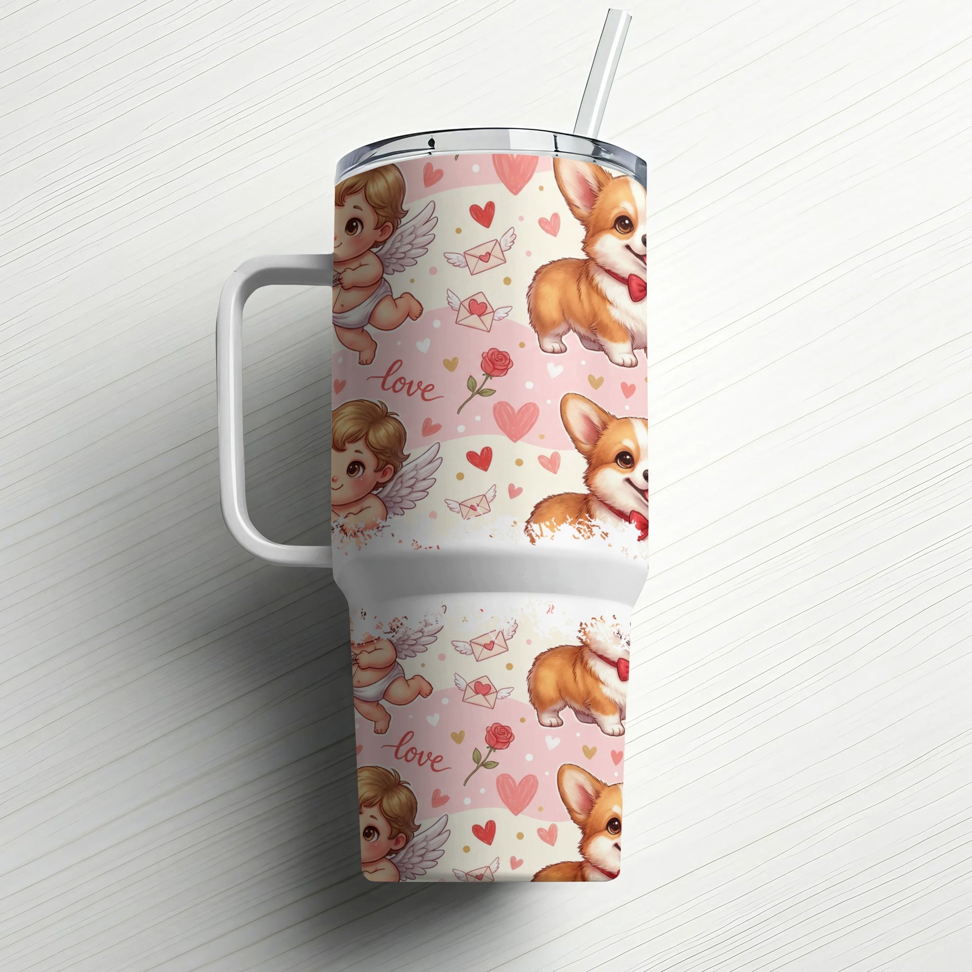 Tumbler with corgi and cupid graphics on a white wood background.