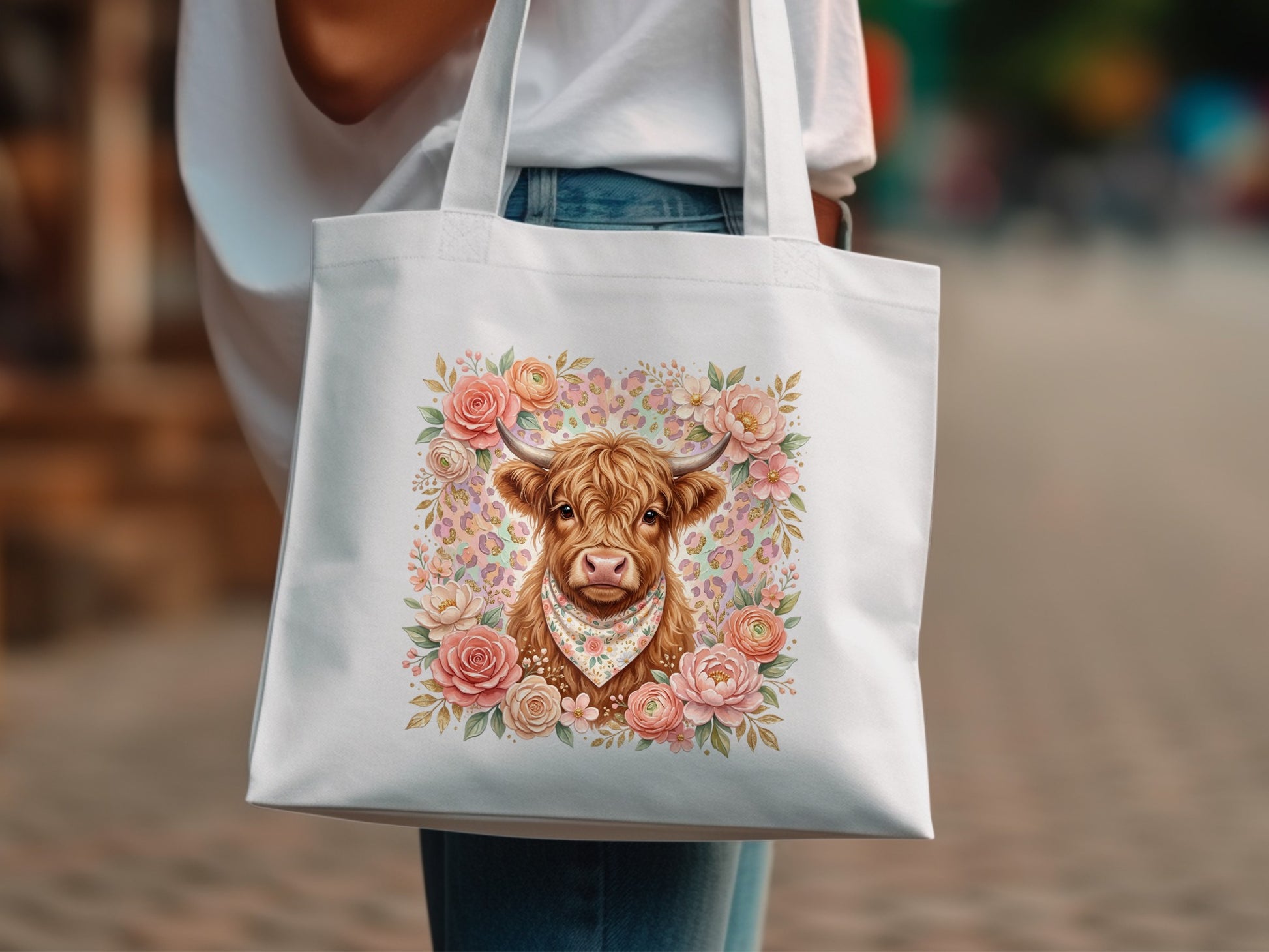 Tote bag with highland cow illustration surrounded by flowers and floral pattern.