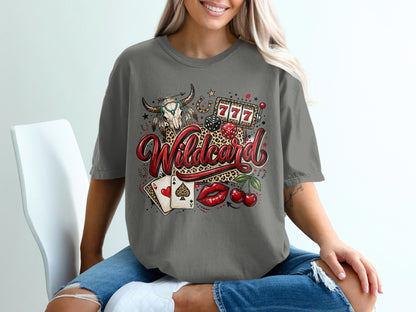 Woman wearing gray t-shirt with "Wildcard" skull, cards, dice, cherries, and slot machine graphic.