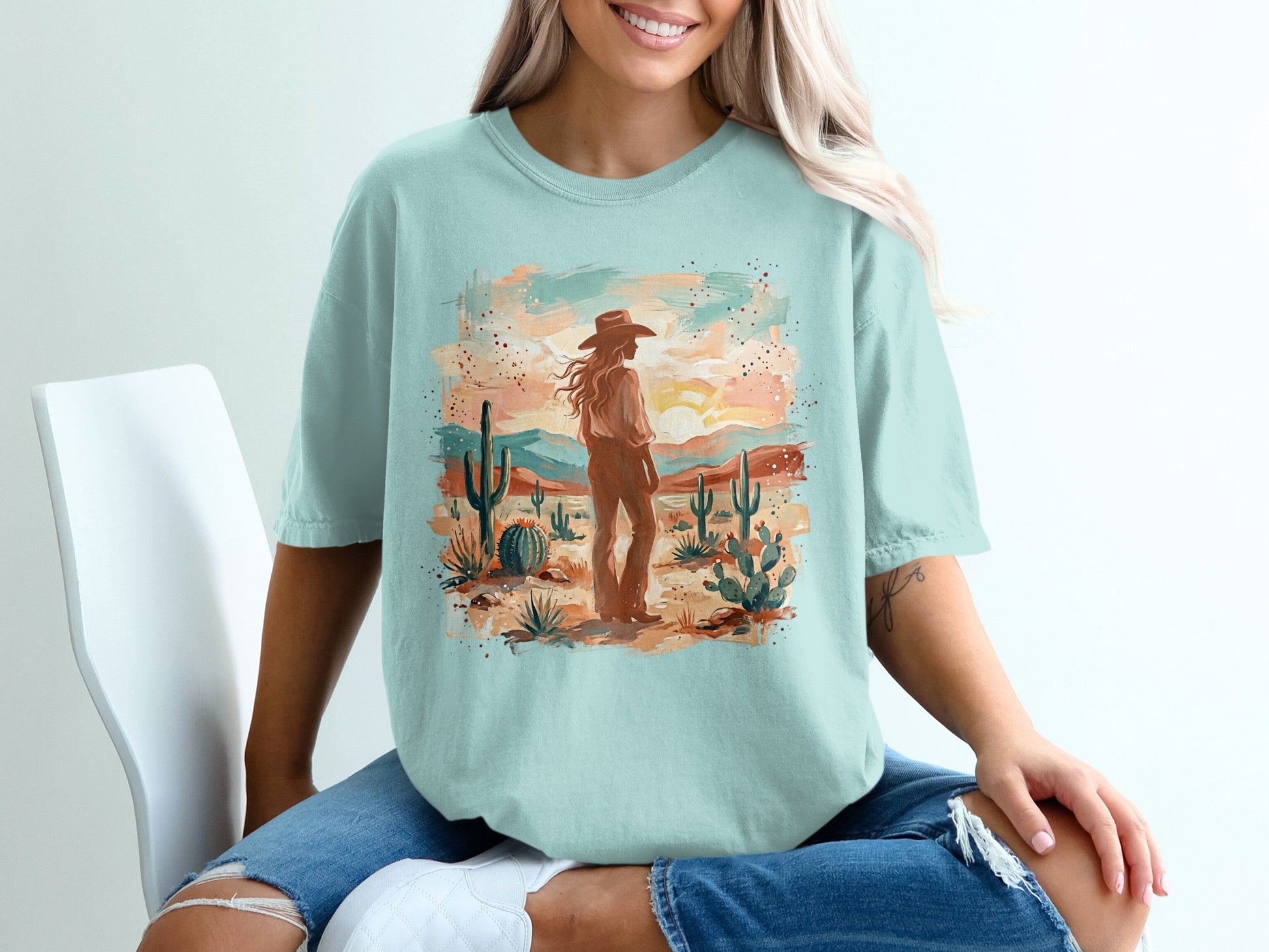 Desert landscape with cactus and sun, woman wearing t-shirt.