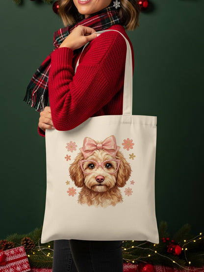 Cream tote bag with cartoon dog wearing pink bow and glasses, surrounded by flowers.