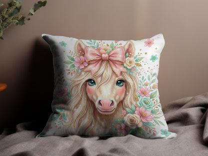Fawn-colored unicorn with blue eyes, pink bow, and floral wreath on pillow.