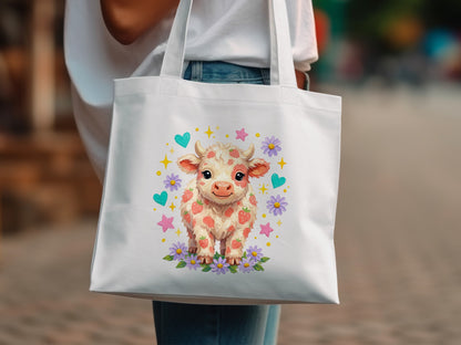 White tote bag featuring a cartoon strawberry cow illustration with hearts and flowers.