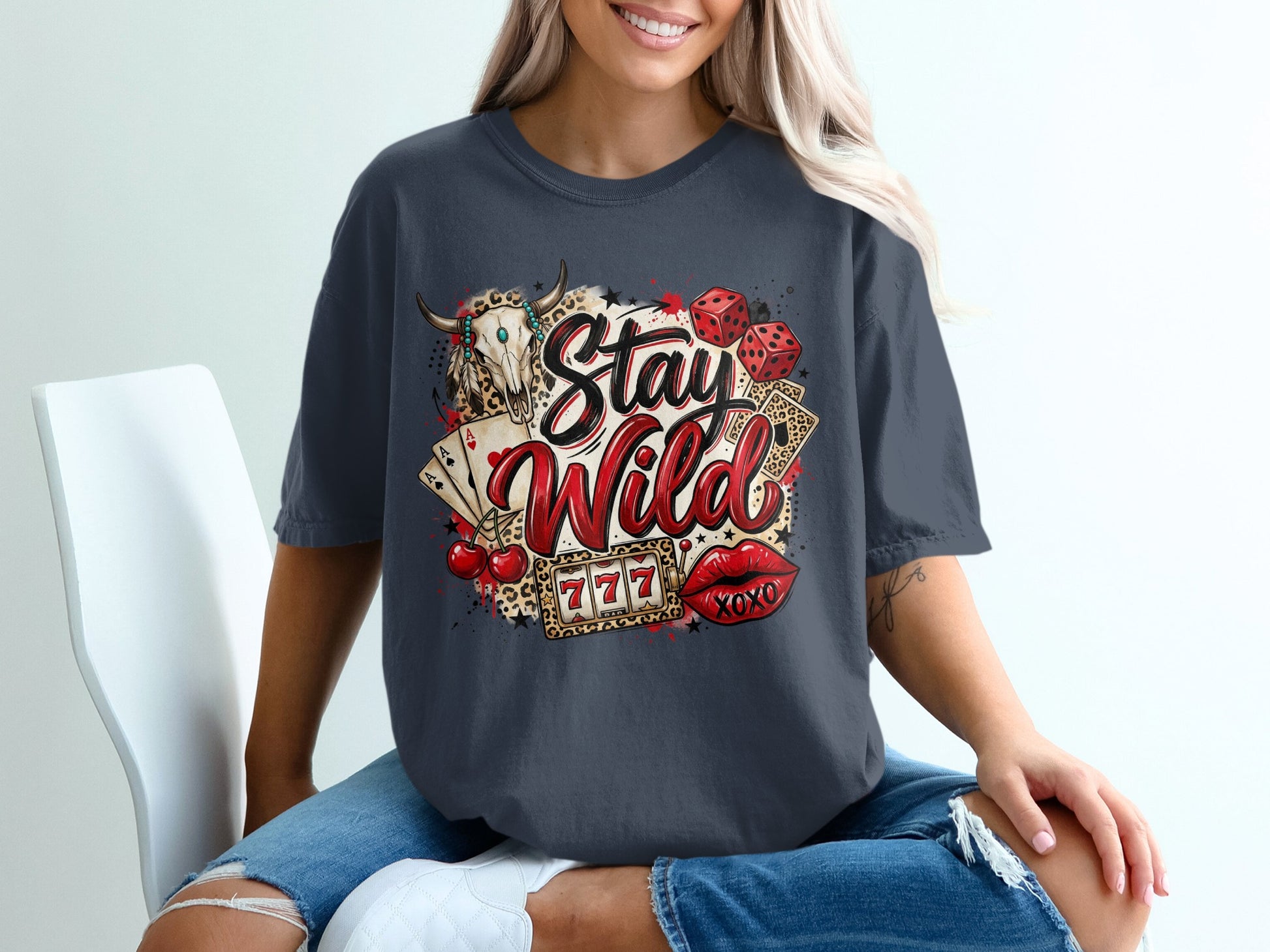T-shirt graphic with "Stay Wild" text, bull skull, dice, cards, cherries, and lips.