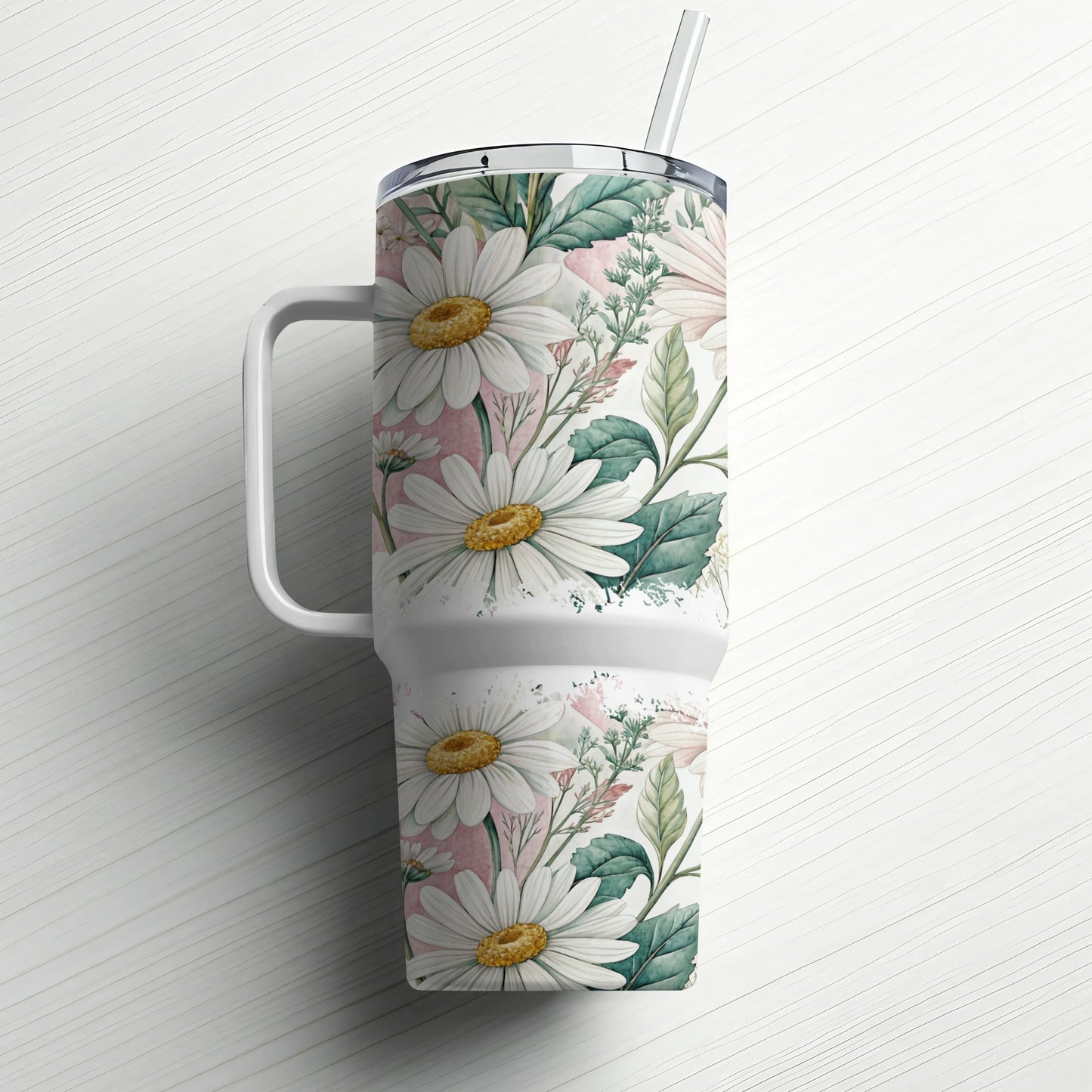 White tumbler with daisies, greenery, and pink accents, with a straw.